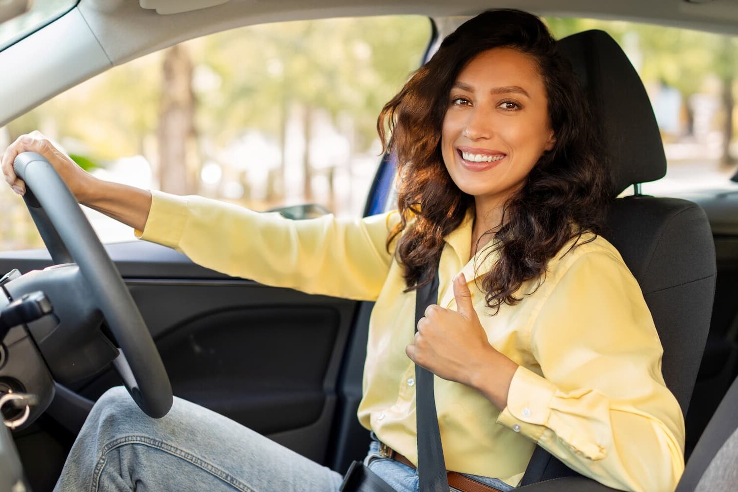 happy-european-woman-showing-thumb-up-smiling-sitting-inside-new-modern-car-first-road-trip-1-e1743712420922.jpg